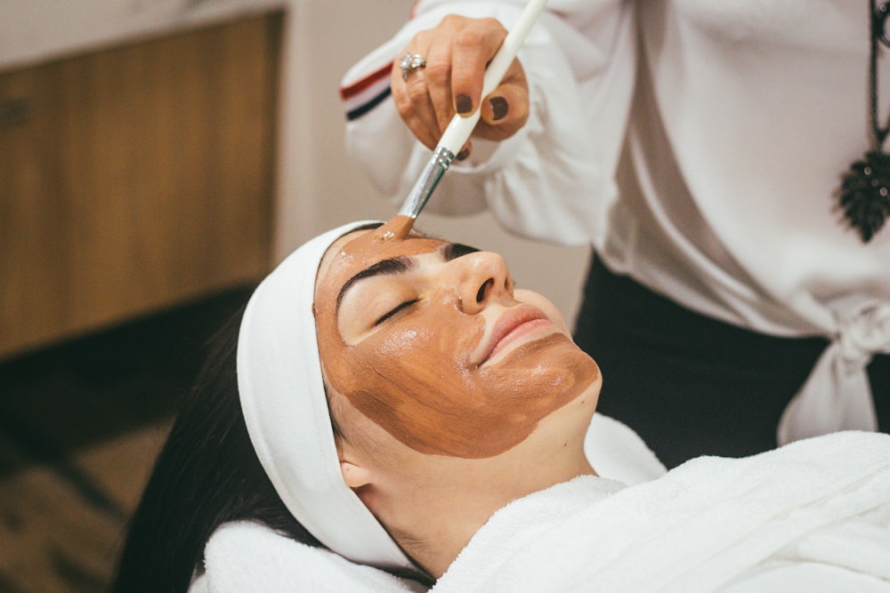 Spa therapist preparing warm oils and flowers