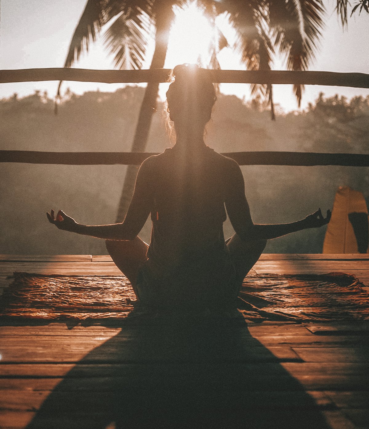 Guest meditating on the yoga deck at sunrise